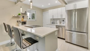A modern kitchen with a central island, stainless steel appliances, and pendant lighting. - RiversideStar: Pompano Retreat, close to beach (Pompano Beach)