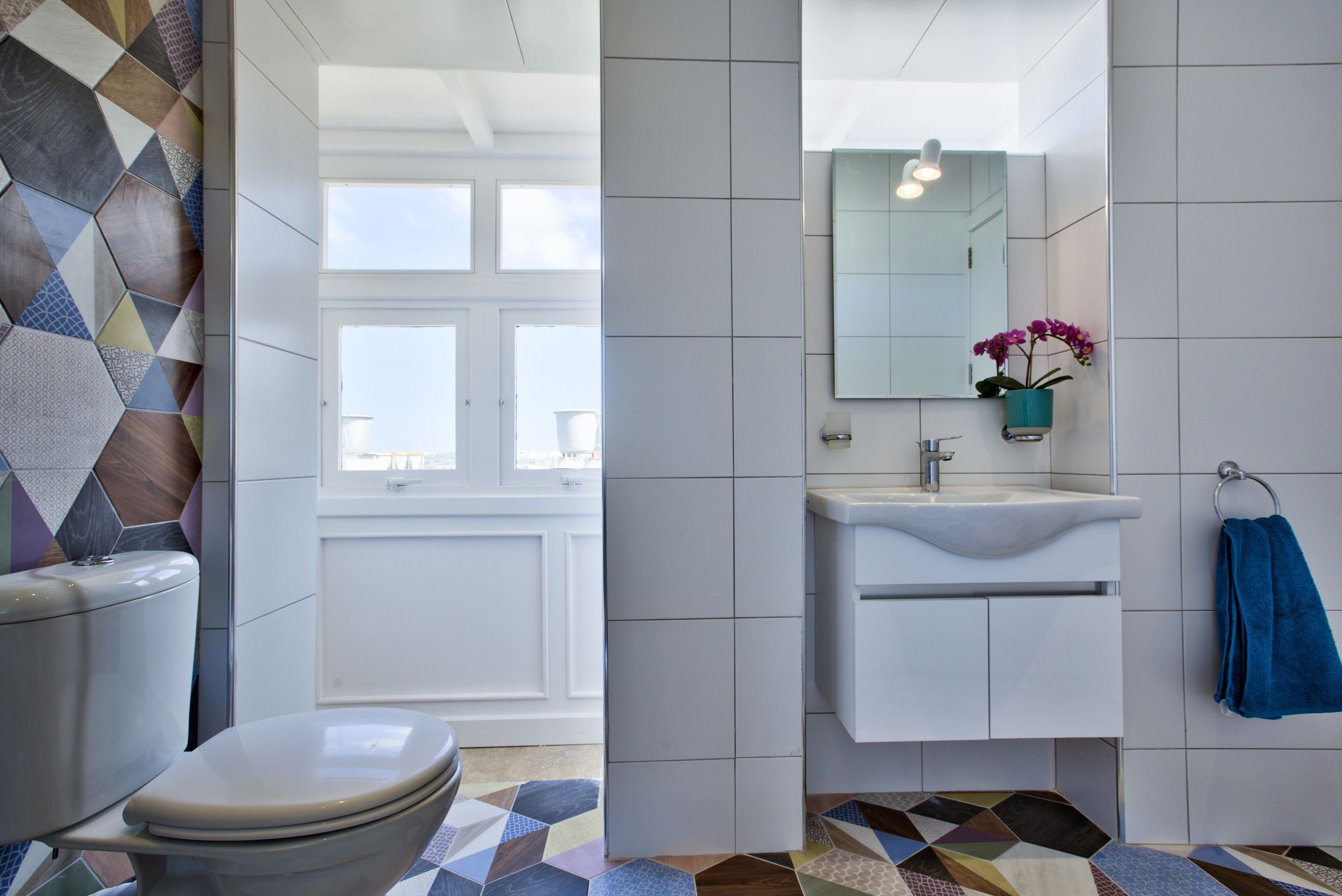 A modern bathroom with a toilet, sink, and mirror.