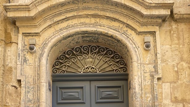 A double door with ornate metalwork and a stone archway. - Ursula Suites- Self Catering Apartments- Valletta- by Tritoni Hotels (Valletta)
