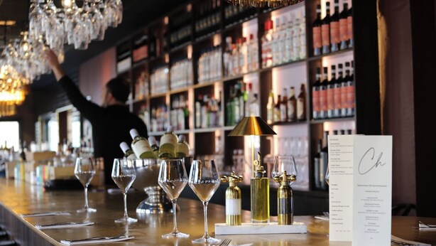 Un espace bar avec des verres, des bouteilles et un menu.
