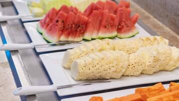 Un bufé con sandía en rodajas, queso y zanahorias.