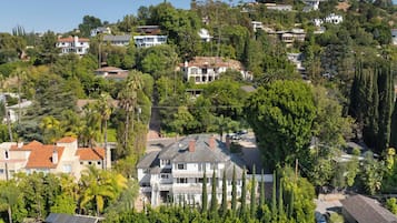 A residential area with houses surrounded by trees and hills.