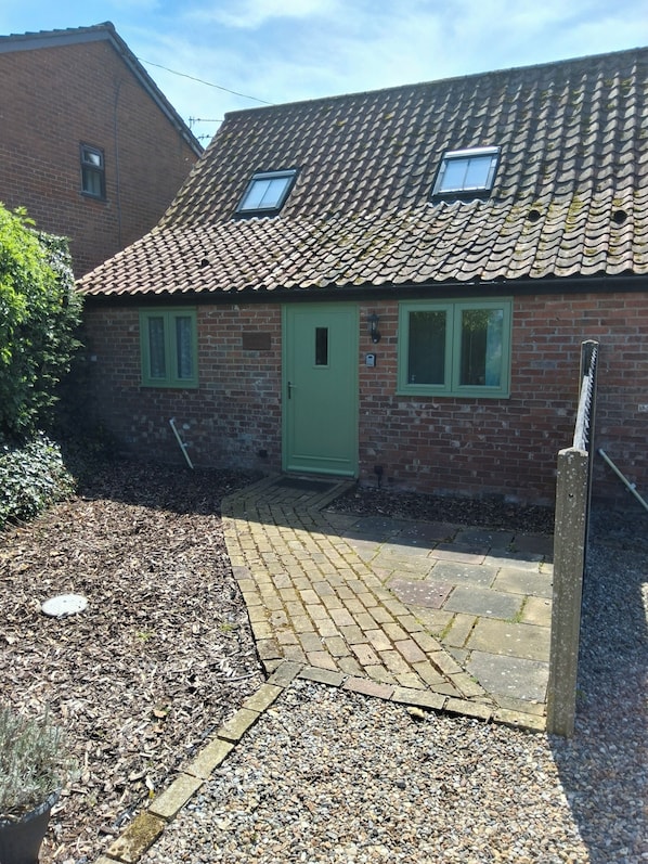 A brick house with a tiled roof, a green door, and two windows. - Country Views peaceful location in superb setting close to the Norfolk Broads (Loddon)