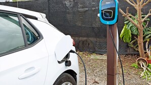 A white car parked next to a charging station.
