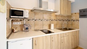 A modern kitchen with a microwave, stove, sink, and wooden cabinets.