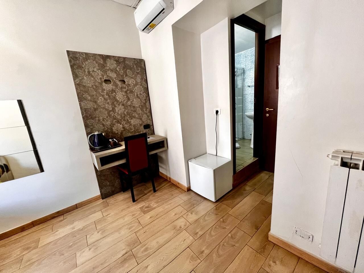 Une pièce comprenant un bureau, une chaise et un petit meuble blanc.