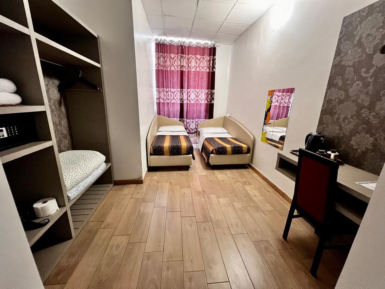 Habitación pequeña con una cama litera, un escritorio, una silla y un armario.