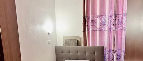 A bedroom with a bed, bedside table, and a nightstand.