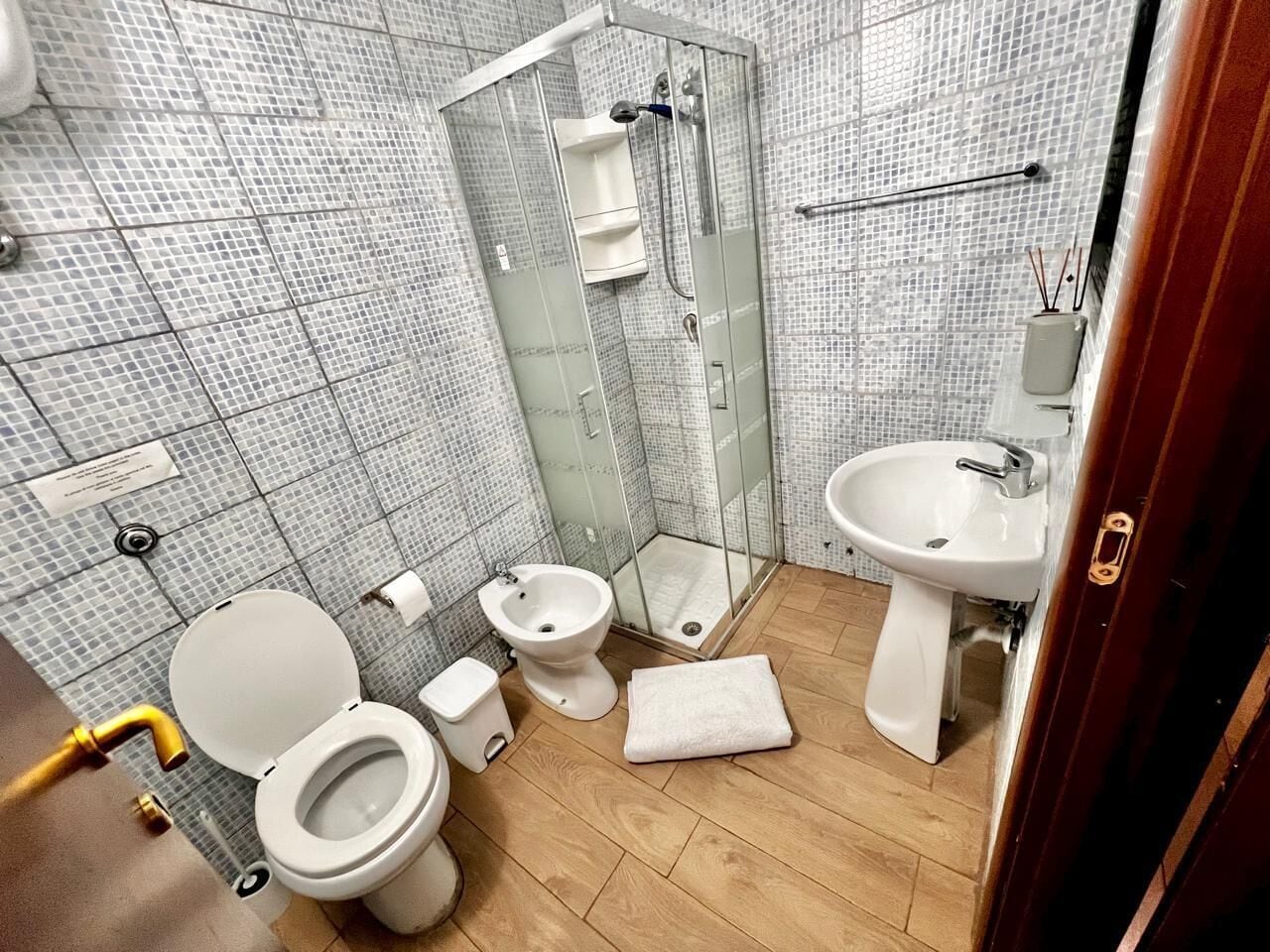 A bathroom with a toilet, bidet, and shower.