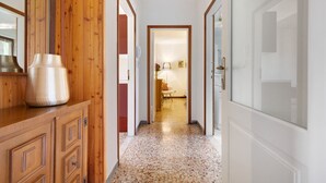 A hallway with wooden paneling, a large vase, and a door leading to a room with a lamp and chair. - Holiday Apartment "Jose" with Shared Pool, Terrace & Wi-Fi (Tremosine)