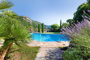 Una piscina rodeada de vegetación y un paisaje montañoso.