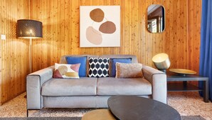 A modern living room with a grey sofa, patterned cushions, a wall-mounted abstract painting, a floor lamp, a mirror, and a side table with a bowl. - Holiday Apartment "Jose" with Shared Pool, Terrace & Wi-Fi (Tremosine)