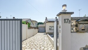 A narrow alleyway with a stone-tiled path, a gated entrance, and a building with the number 17B. - Holiday Home 'Allegra' with Private Pool, Wi-Fi and Air Conditioning (L'Escala)