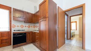 A kitchen with wooden cabinets, a stove, and a tiled backsplash.