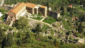 An aerial view of a historic building complex with ruins and a large central structure. - Pine Forest Chalet 1400m | Cinema & Fireplace (Artemisia)