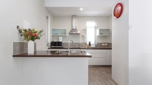 Una cocina moderna con una isla central, electrodomésticos de acero inoxidable y un jarrón decorativo.