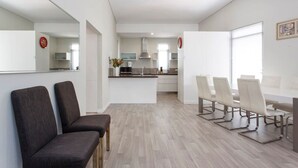 Un interior moderno con comedor, cocina y zona de estar.