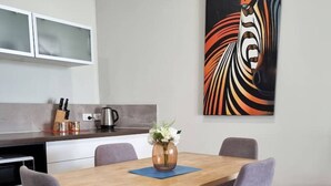 A modern kitchen with white cabinets, a stainless steel range, and a coffee maker. - Waverley apartment D-one bedroom, wifi available (Beckenham)