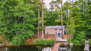 A house by a lake with a dock and a boat. - Winnipesaukee Waterfront Home Sleeping for 8 (Moultonborough)