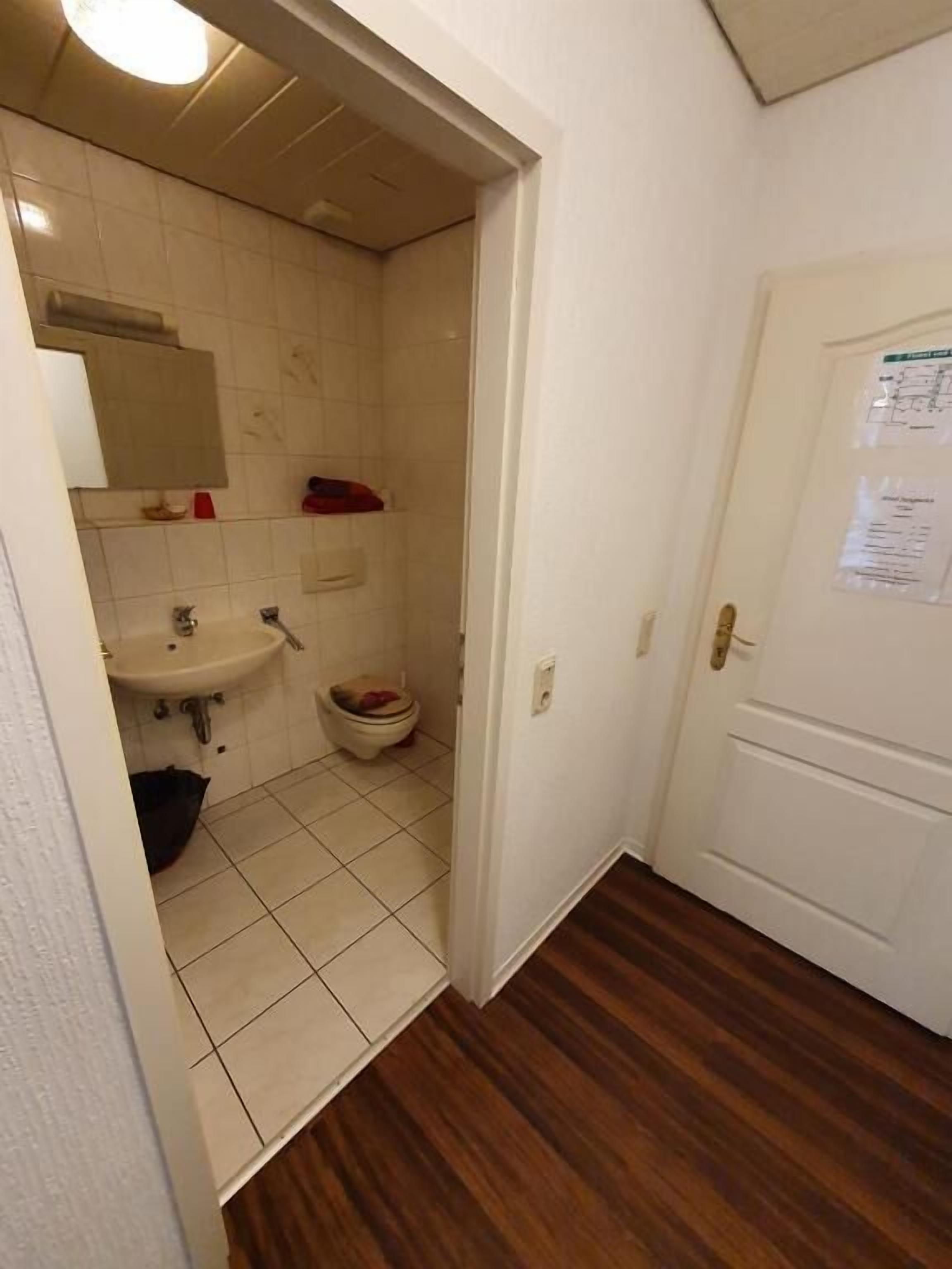 Un baño con lavamanos, inodoro y espejo.
