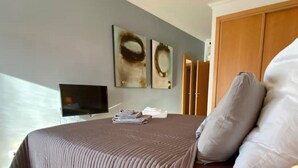Een hotelkamer met een bed, een flatscreen televisie en kunst aan de wand.
