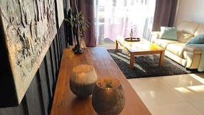 Een woonkamer met een houten salontafel, een bank en twee decoratieve vazen.