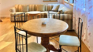Un sal ón acogedor con una mesa redonda de madera, dos sofás y un ventilador de techo.
