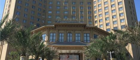 A tall hotel building with a symmetrical facade, multiple windows, and a central entrance.