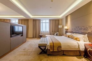 A hotel room with a large bed, a television, a bedside table, and a window with curtains. - Fuxin International Hotel (Shangrao)