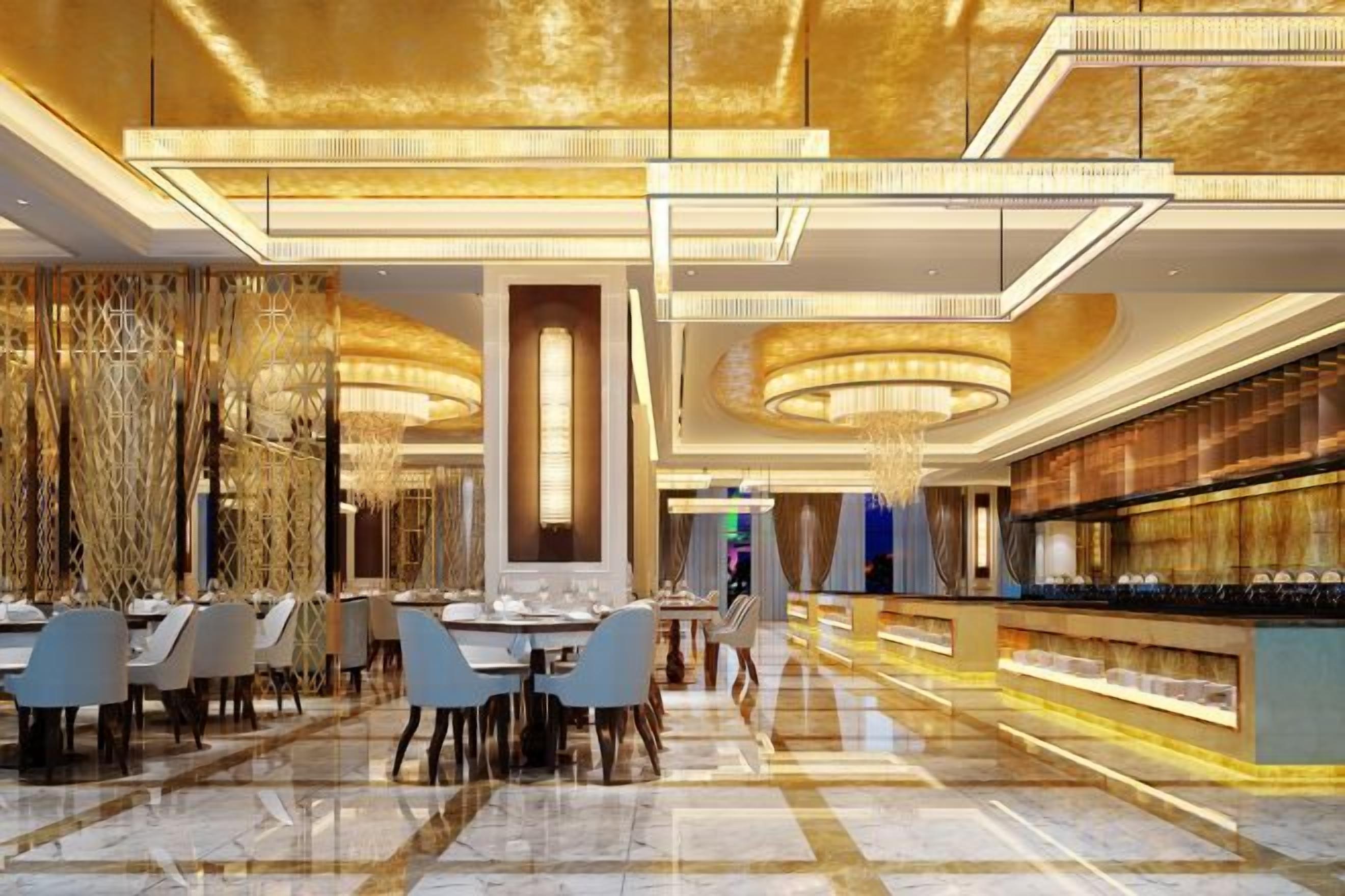 A spacious lobby with a high ceiling, chandeliers, and a bar area.