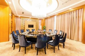 A conference room with a round table, chairs, and a chandelier. - Fuxin International Hotel (Shangrao)