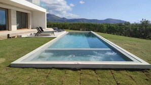 A modern house with a rectangular swimming pool, a grassy lawn, and a mountain view. - Casa le Cicale the top villa in Falasarna,Basketbal,pool,BBQ (Phalasarna)