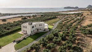 A modern house with a flat roof, large windows, and a paved driveway. - Casa le Cicale the top villa in Falasarna,Basketbal,pool,BBQ (Phalasarna)