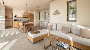 Una sala moderna con sofá, mesa de comedor y zona de cocina.