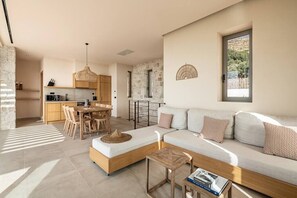 Uma sala moderna com sofá, mesa de jantar e espaço de cozinha.