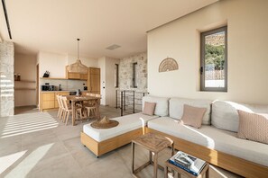Un salon moderne avec un canapé, une table à manger et une cuisine en arrière-plan.