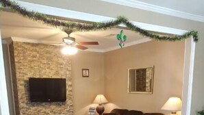 A living room with a fireplace, a sofa, a coffee table, and a television mounted on the wall.