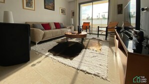 Una sala de estar moderna con un sofá, una mesa de centro y un televisor de pantalla plana.