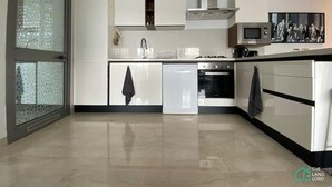 Una cocina moderna con armarios blancos, lavavajillas, horno y microondas.