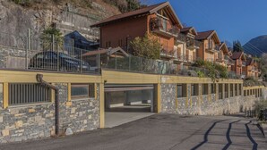 A row of multi-story buildings with balconies, a stone facade, and a clear sky. - casa_andrea_varenna_varennaholidays (Perledo)