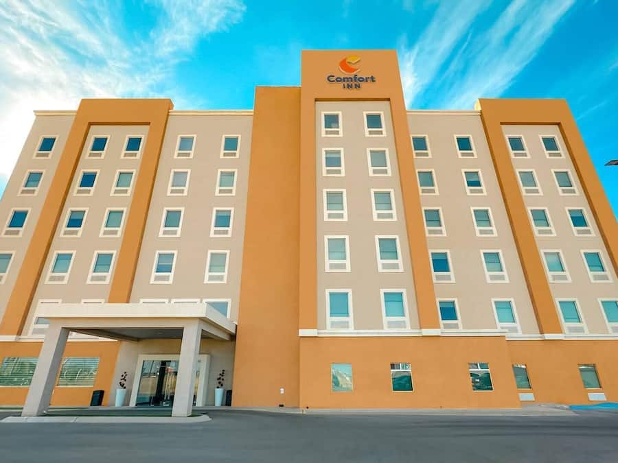 A multi-story hotel with a central entrance, large windows, and a prominent Comfort Inn logo.