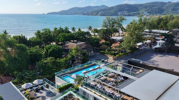 A rooftop pool area with a view of the sea and hills. - Clarian Hotel Beach Patong (Patong)