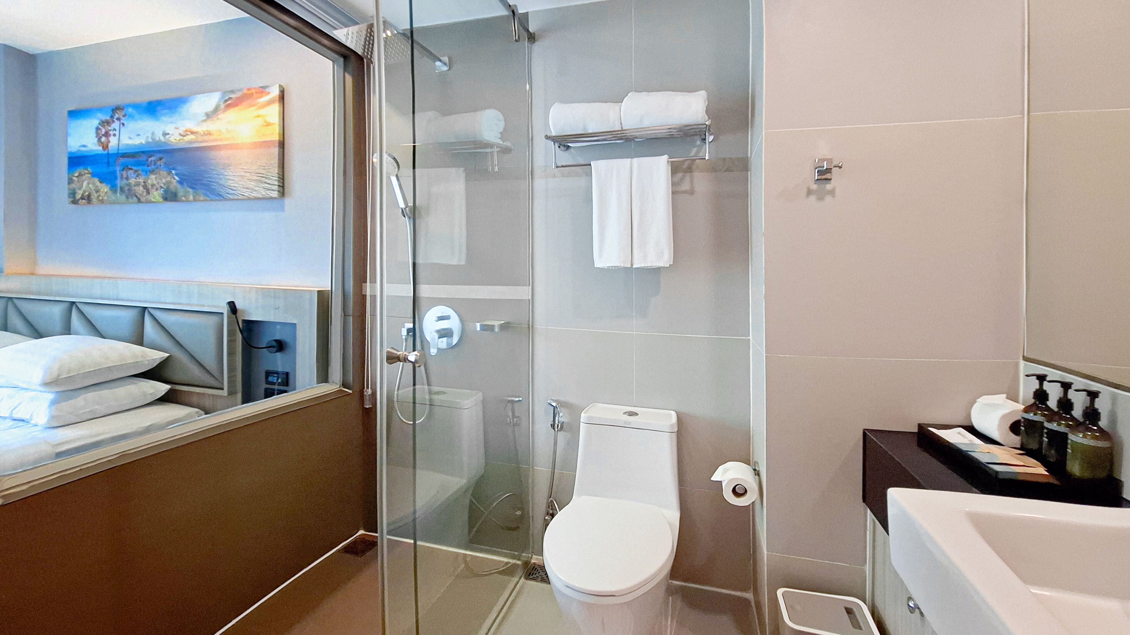 Een moderne badkamer met een douchecabine, toilet en bad.