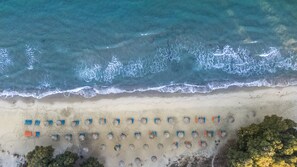 Privat strand, vit sandstrand, solstolar och parasoller