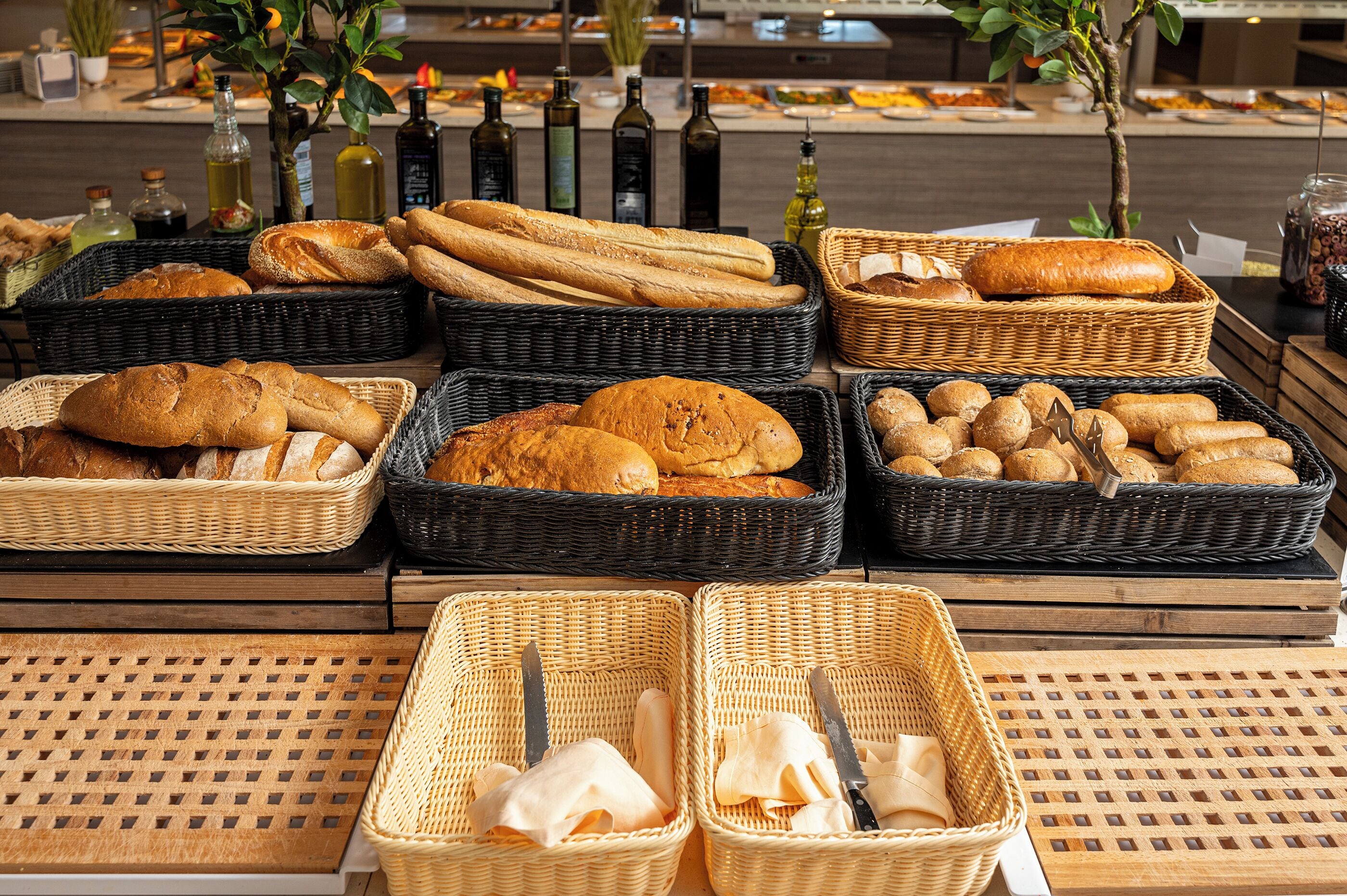 A buffet table with various breads and baskets.