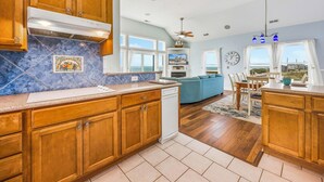 Una cocina moderna con armarios de madera, salpicadero de mármol y una isla grande.