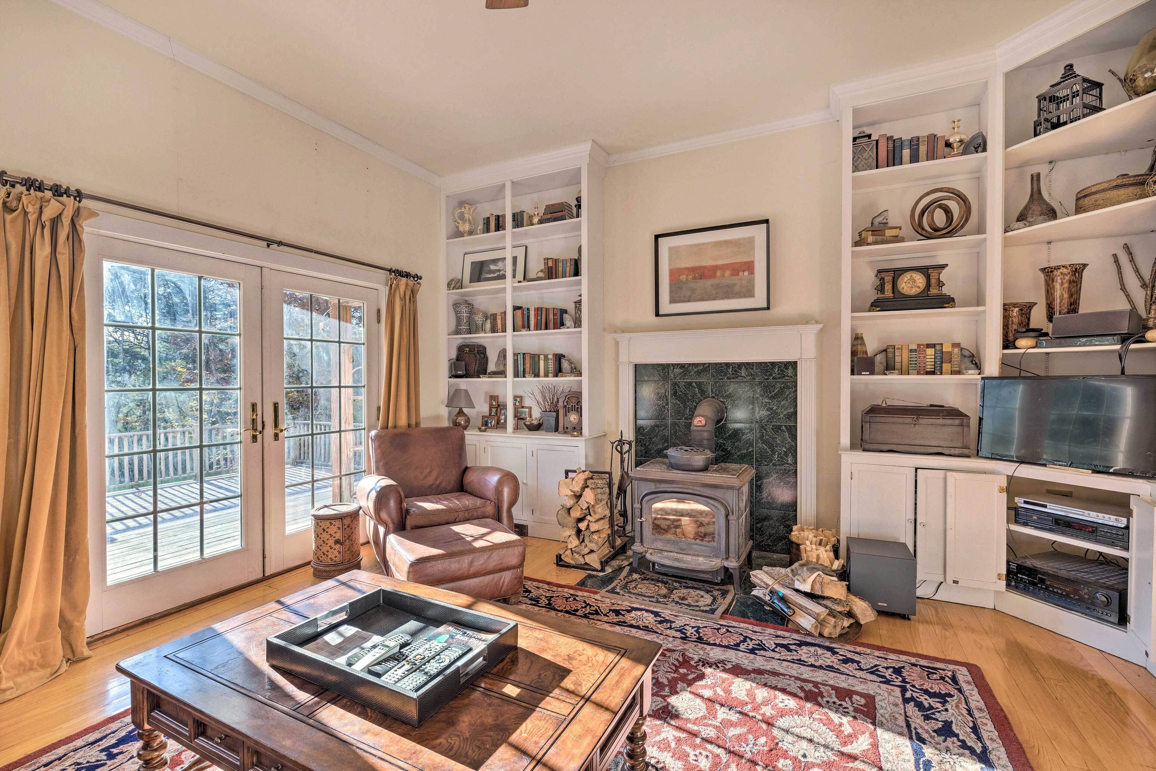 Una sala de estar acogedora con chimenea, estanterías y un sillón de cuero.