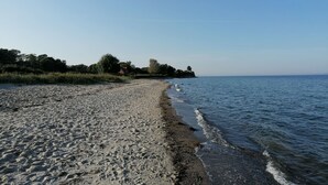 Una playa con arena y agua tranquila.