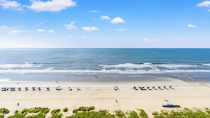 Une plage avec des parasols et des gens.