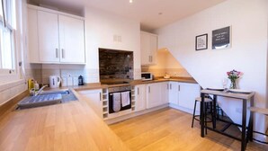 A modern kitchen with white cabinets, a wooden countertop, and a built-in oven.